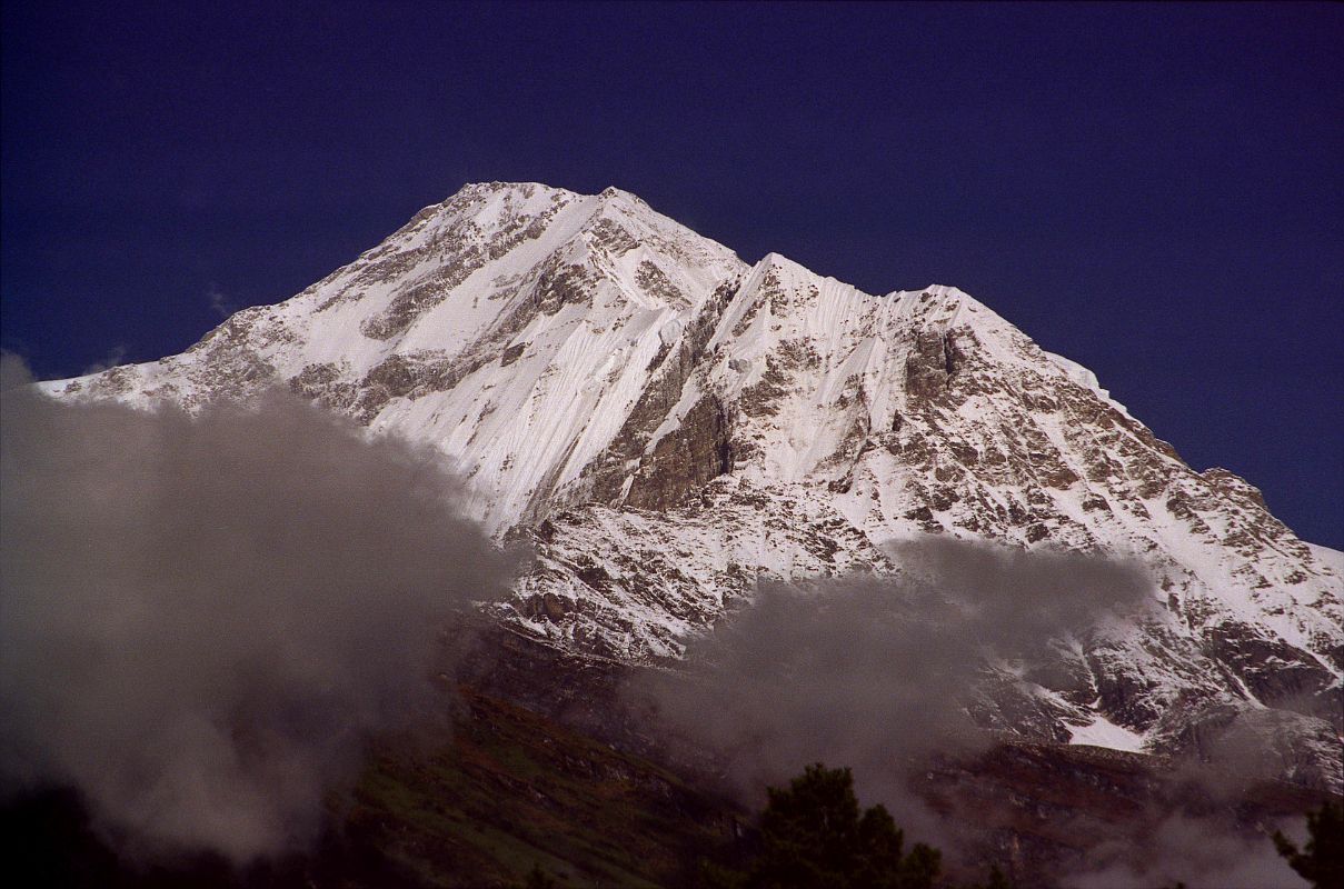 407 Dhaulagiri South Face Early Morning From Lete �Above this stony desert Dhaulagiri rose into swirling clouds, vast and solitary. For twenty thousand feet there was nothing but the glint of riven glaciers, ridges that seemed like streamers in the wind, and somber rock buttresses higher than the Walker. The sight was so overwhelming that we sat down by the side of the trail feeling slightly numbed� (Lionel Terray, Conquistadors of the Useless).